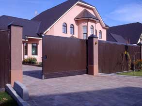 Довольно часто цвет ворот подбирается под цветовую гамму крыши, так как эти два элемента дома хорошо видны даже издалека